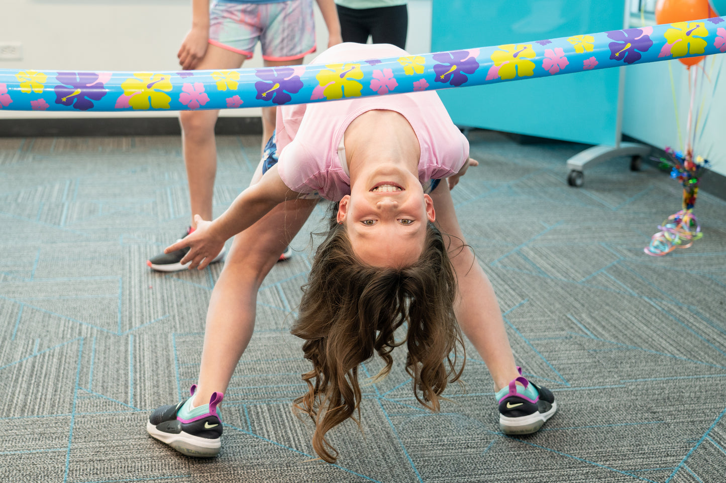 Girl playing limbo at a class party.